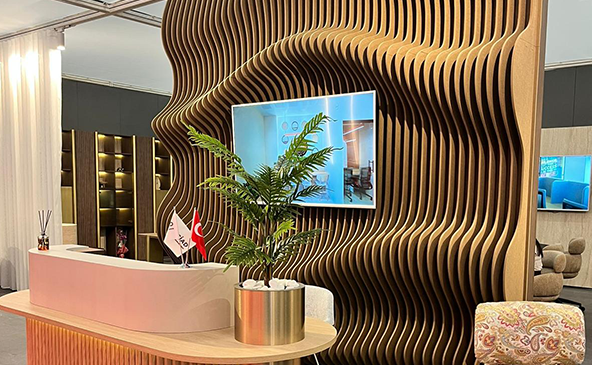 3D parametric wave pattern acoustic PET felt wall panel installation at Çağın Office reception area featuring dramatic organic wave design with wooden desk and plants – FeltVibe