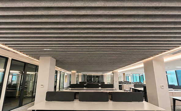Acoustic PET felt ceiling baffle panels installed in an open-plan office in Denizli Turkey providing sound absorption across the ceiling – FeltVibe baffle application